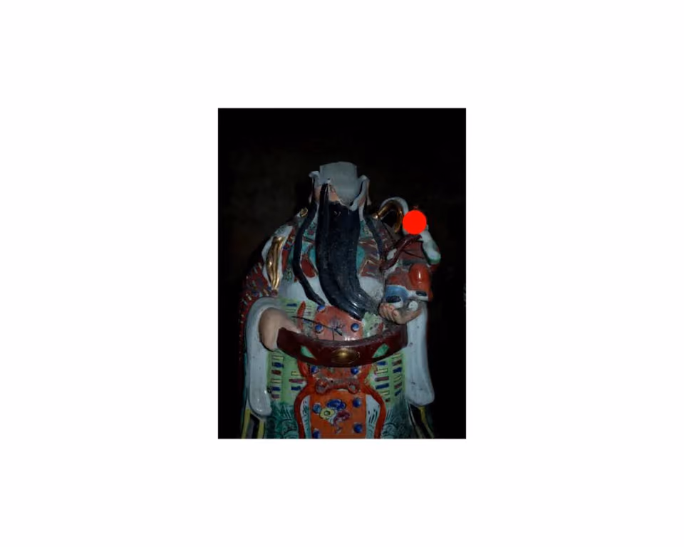白底中央小图：黑背景前一尊长须彩绘人物瓷像，脸旁一枚红点