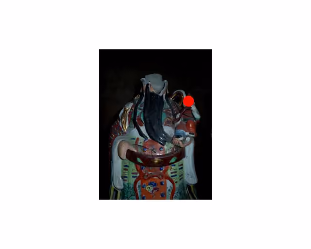 白底中央小图：黑背景前一尊长须彩绘人物瓷像，脸旁一枚红点